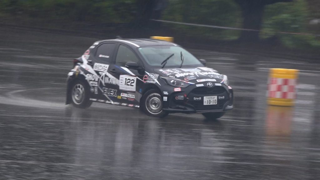 e 投票 FLEX SHOW AIKAWA Racing ORC ヤリスが雨天の中走行している画像